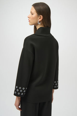 Black jacket with white circular patterns on cuffs and hem worn by a person on a white background