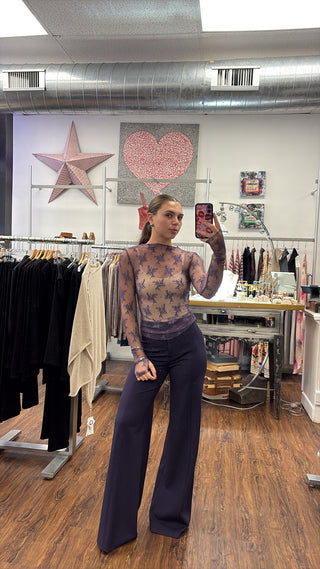 woman wearing a styled outfit with lace top and purple wide leg trousers 