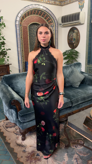 Woman wearing rose print halter maxi dress with scattered floral design