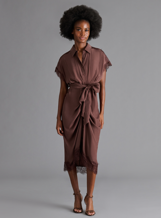 Woman wearing a chocolate brown tie waist midi dress with lace trim, surplice neckline, and short sleeves.